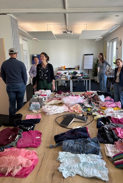hms-beruf-familie-mini-kleidertausch Mitarbeitende beim HMS Mini-Kleidertausch für gebrauchte Kinderkleidung.